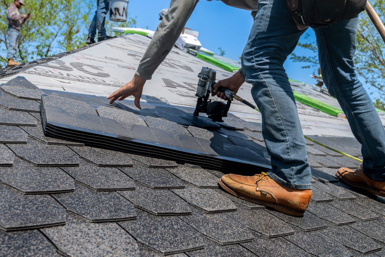 Close-up of a nail gun fastening shingles on a roof